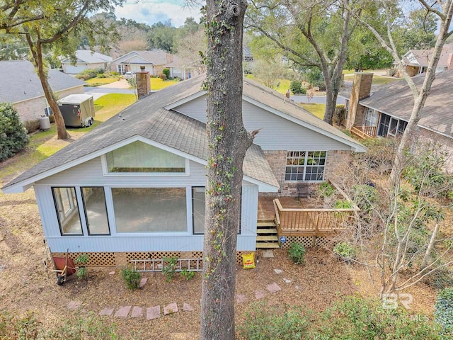 exterior space with roof with shingles, a wooden deck, a residential view, and central air condition unit