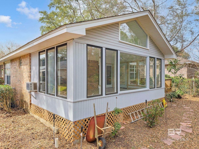 view of home's exterior with a sunroom and brick siding