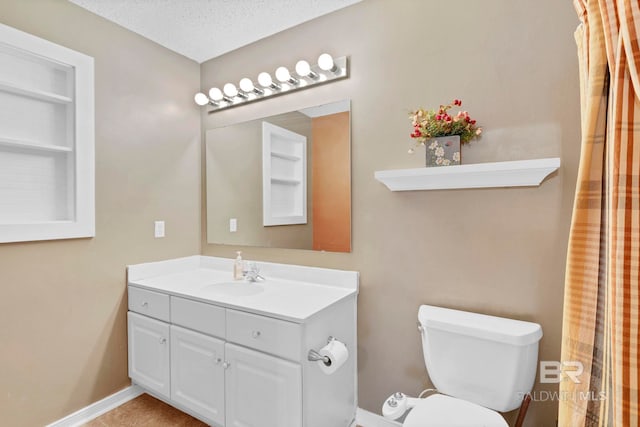 bathroom with a textured ceiling, vanity, toilet, and baseboards