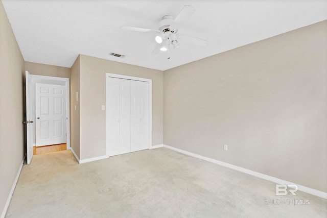 unfurnished bedroom with ceiling fan, light carpet, visible vents, baseboards, and a closet