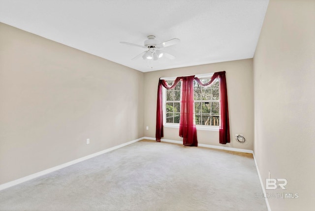 unfurnished room featuring a ceiling fan, light colored carpet, and baseboards