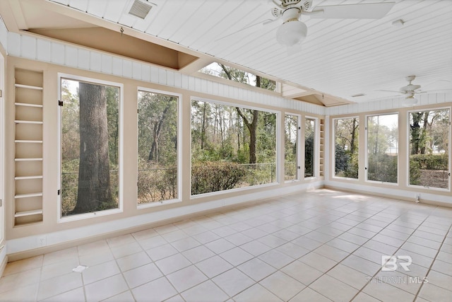 unfurnished sunroom with a ceiling fan and vaulted ceiling