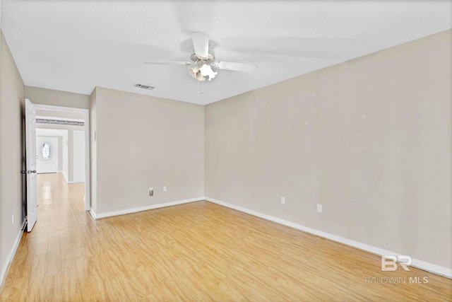 spare room with visible vents, a ceiling fan, light wood-style flooring, and baseboards