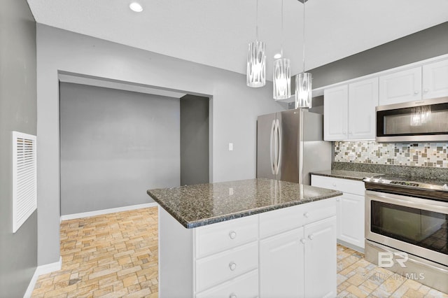 kitchen with a center island, stainless steel appliances, tasteful backsplash, white cabinets, and baseboards