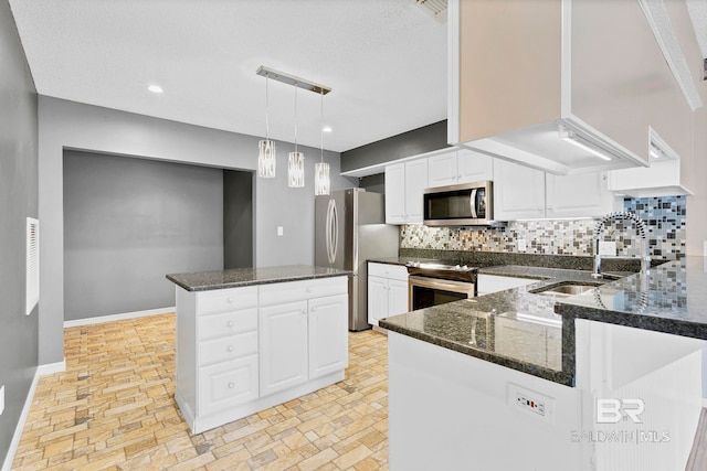 kitchen featuring baseboards, decorative backsplash, dark stone counters, stainless steel appliances, and a sink