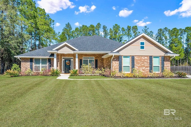 view of front facade featuring brick siding, a front yard, and fence