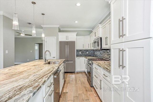 5553 Ponte Verde Rd, Pensacola, FL 32507 - kitchen with visible vents, a sink, ornamental molding, stainless steel appliances, and white cabinetry