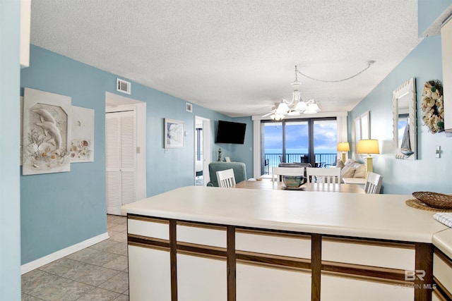 24522 Perdido Beach Blvd Unit 4909, Orange Beach, AL 36561 - kitchen with a chandelier, open floor plan, a textured ceiling, white cabinetry, and light countertops