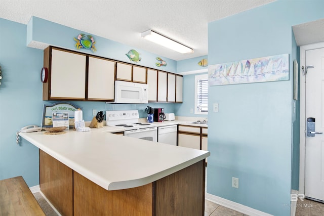 24522 Perdido Beach Blvd Unit 4909, Orange Beach, AL 36561 - kitchen with white appliances, a peninsula, light countertops, a textured ceiling, and white cabinets