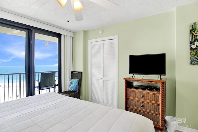 24522 Perdido Beach Blvd Unit 4909, Orange Beach, AL 36561 - bedroom with a closet, a textured ceiling, a water view, and ceiling fan