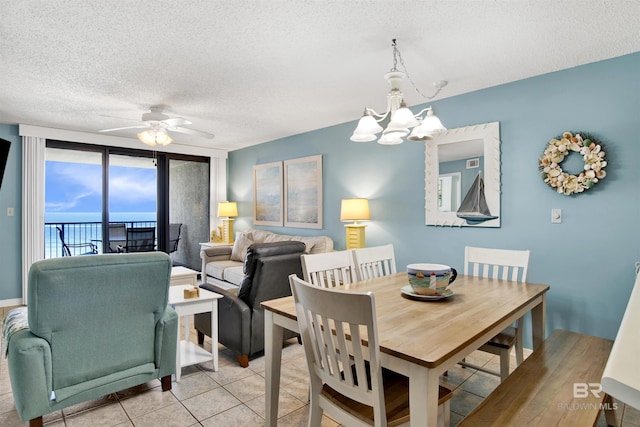 24522 Perdido Beach Blvd Unit 4909, Orange Beach, AL 36561 - dining room with a chandelier, a ceiling fan, a textured ceiling, and light tile patterned floors