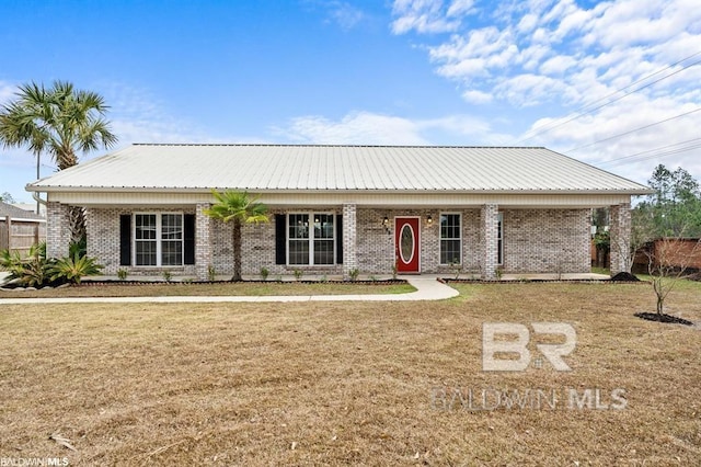 view of front of property with brick siding, metal roof, and a front lawn