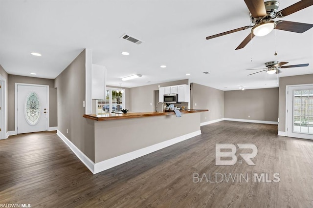 interior space featuring recessed lighting, dark wood finished floors, visible vents, and baseboards