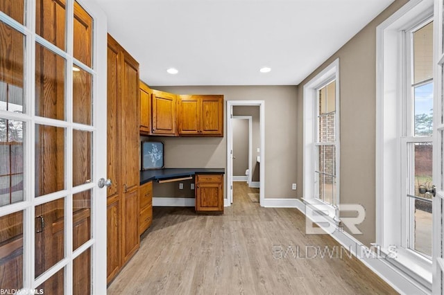 unfurnished office featuring recessed lighting, built in study area, light wood-style flooring, and baseboards