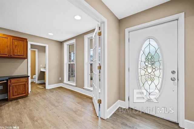 entryway featuring light wood finished floors, recessed lighting, and baseboards