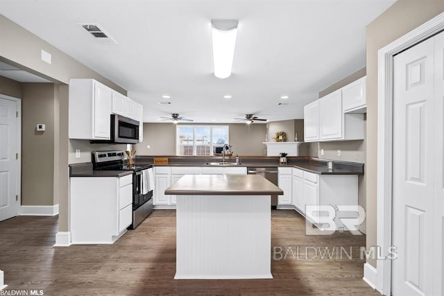 kitchen with stainless steel appliances, white cabinets, visible vents, and a peninsula