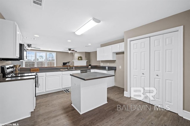 kitchen with appliances with stainless steel finishes, dark countertops, visible vents, and white cabinetry