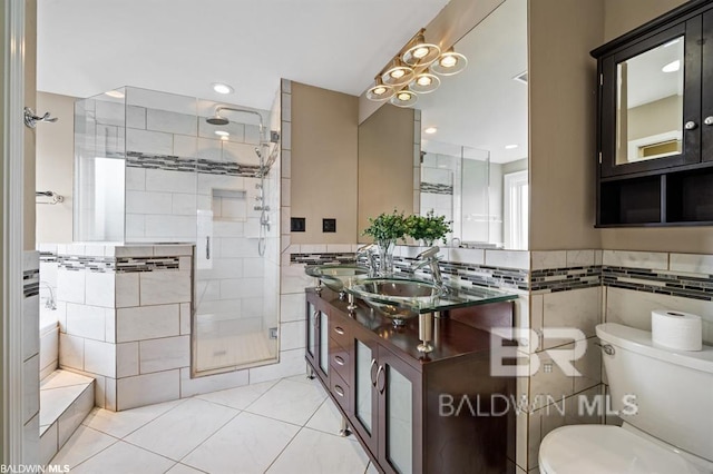 full bathroom featuring tile walls, toilet, a stall shower, vanity, and tile patterned floors