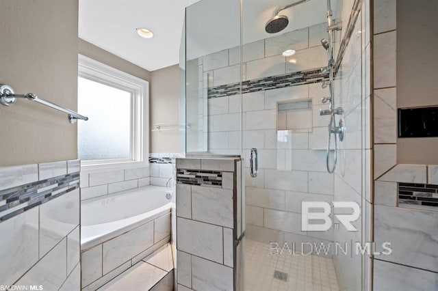 full bathroom with a shower stall and a bath