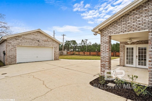 view of patio with a garage, french doors, fence, and an outdoor structure