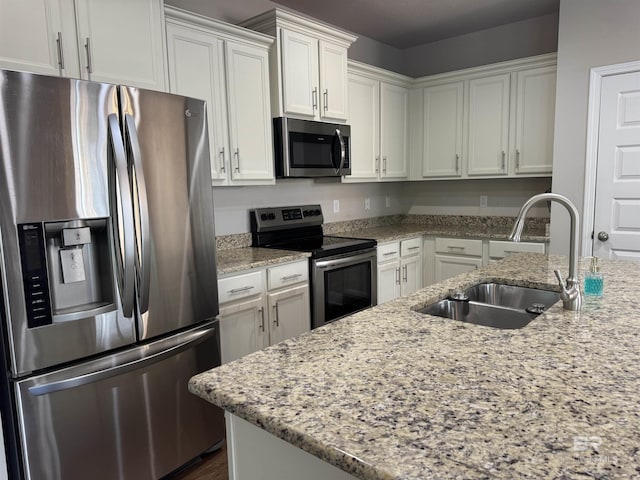 6811 Spaniel Dr Unit C, Spanish Fort, AL 36527 - kitchen featuring stainless steel appliances, a sink, white cabinetry, and light stone counters