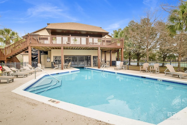 pool with stairs, a patio, fence, and a wooden deck