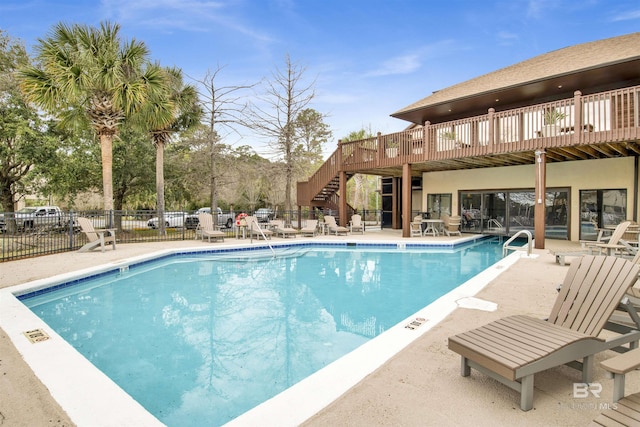 pool featuring stairway and fence