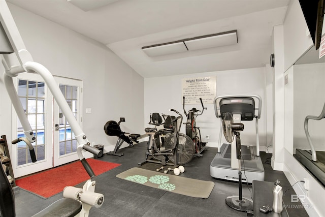 workout room featuring baseboards, vaulted ceiling, and french doors