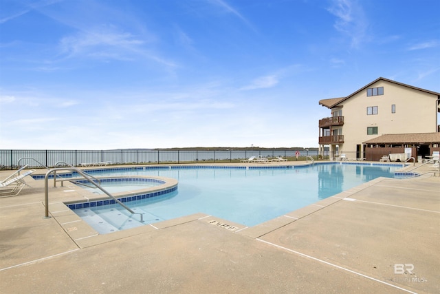 pool with a patio area, fence, and a community hot tub