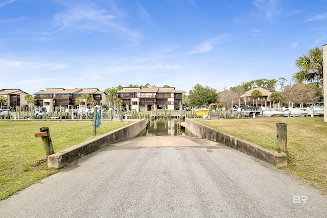 view of street with a water view and aphalt driveway