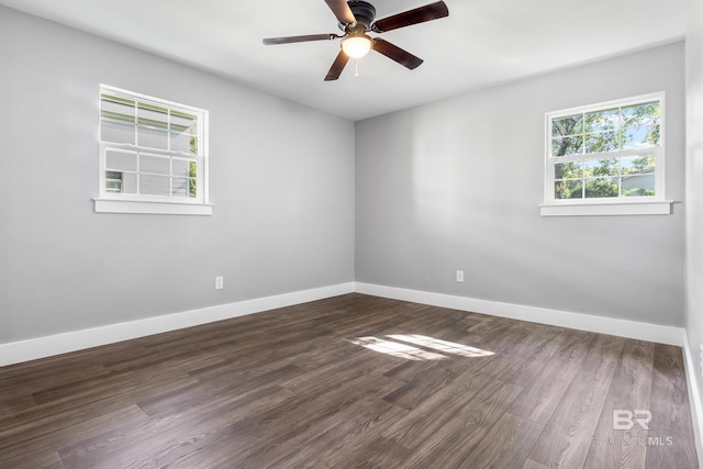 empty room with ceiling fan and dark hardwood / wood-style flooring