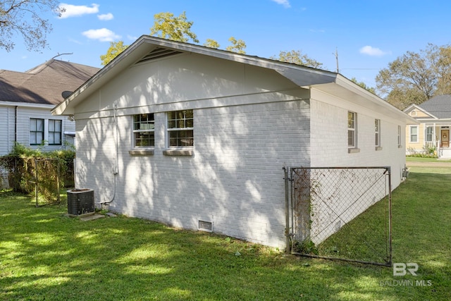 view of side of property with a yard and central AC unit