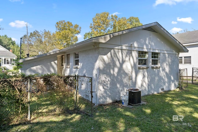 view of side of property with a lawn and central AC