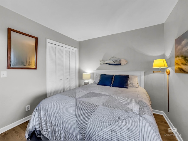 bedroom with dark hardwood / wood-style flooring and a closet