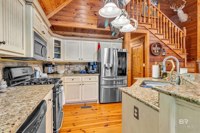 42168 Bayou Rd, Bay Minette, AL 36507 - kitchen with stainless steel appliances, light wood finished floors, backsplash, glass insert cabinets, and light stone countertops
