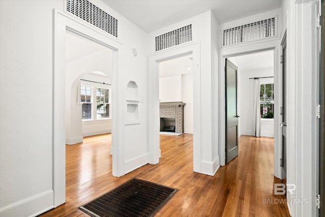 corridor with a healthy amount of sunlight and hardwood / wood-style floors