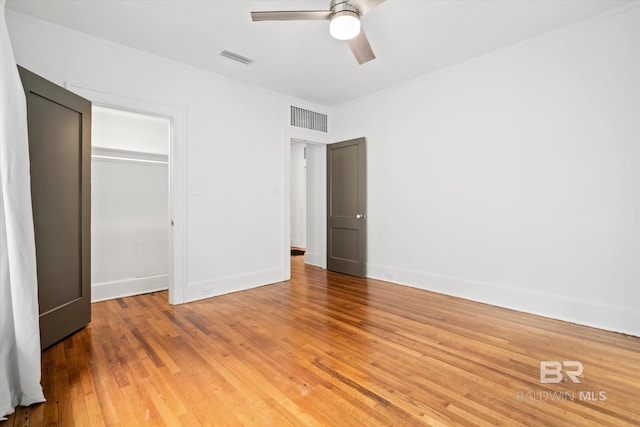 unfurnished bedroom featuring wood-type flooring, ceiling fan, and a closet