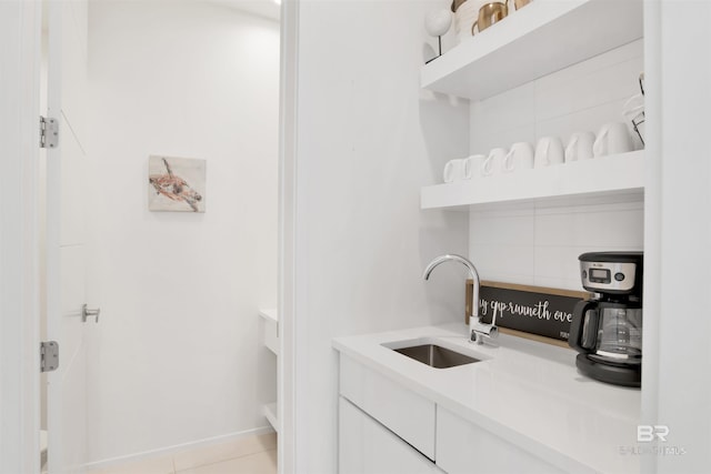 laundry area with sink and light tile patterned floors
