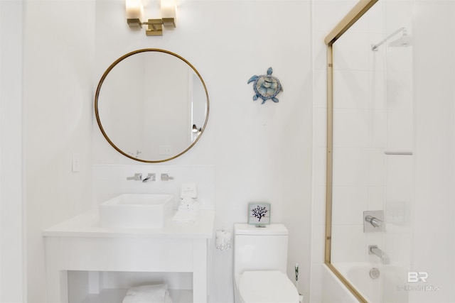 full bathroom with bath / shower combo with glass door, toilet, and sink