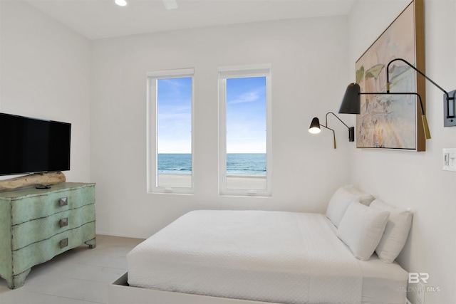 bedroom featuring a water view and ceiling fan