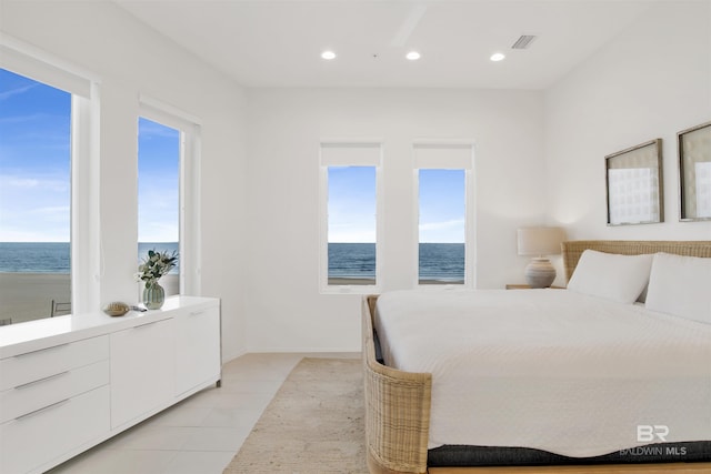 bedroom featuring a water view and light tile patterned flooring