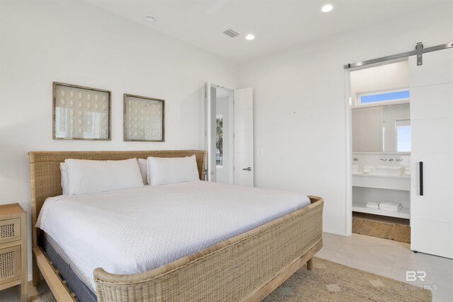 tiled bedroom with connected bathroom and a barn door