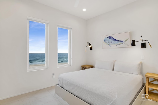 bedroom with a water view, ceiling fan, and light tile patterned flooring