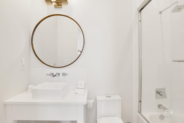 full bathroom with vanity, bath / shower combo with glass door, and toilet