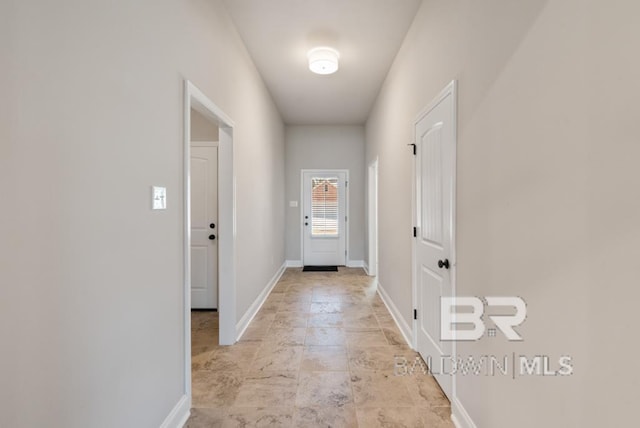 doorway to outside featuring baseboards