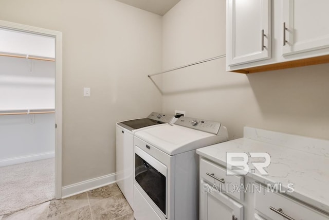 laundry room featuring cabinets, light colored carpet, and washing machine and clothes dryer