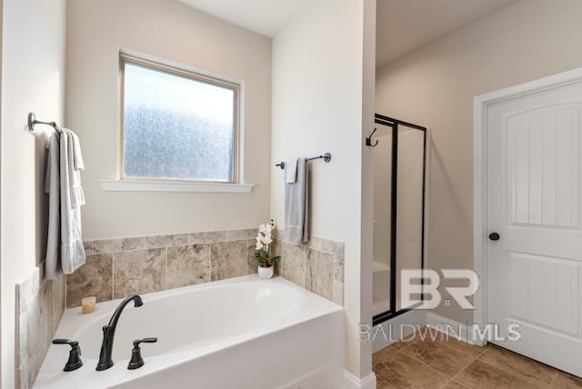 bathroom with a stall shower, a bath, and tile patterned floors