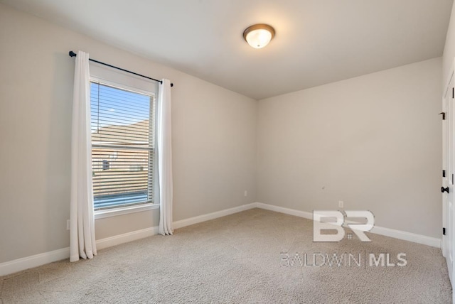 unfurnished room featuring light colored carpet and baseboards