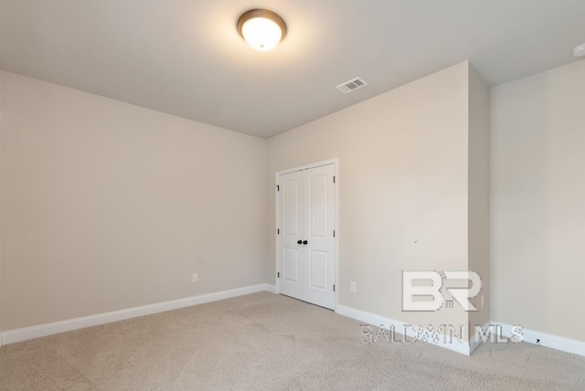 unfurnished room featuring light carpet, visible vents, and baseboards