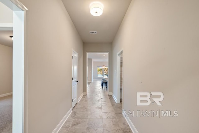 hall with visible vents and baseboards